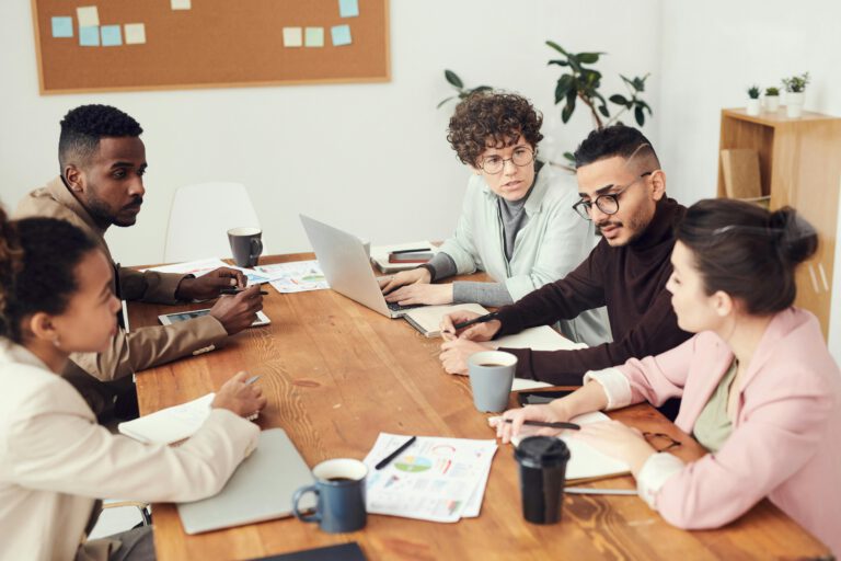 A diverse group of professionals engaged in a collaborative team meeting at the workplace.